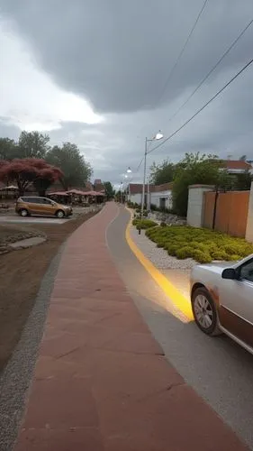 I need the image to depict a paved street with cobblestones, featuring street lighting and sidewalk curbs.,a silver car parked on the street with a light show on its headlamps,long exposure light,car 