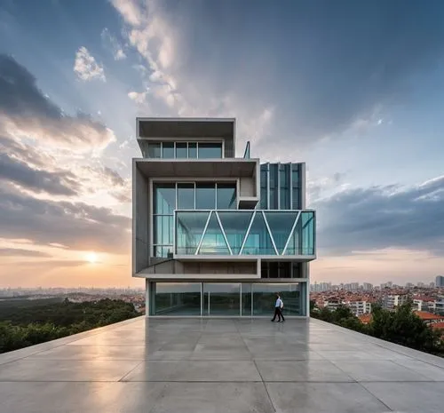 Edificio de 4 pisos, con un volumen saliente en vidrio, de concreto armado blanco y vidrio turquesa trnsparente, marcos de ventana de acero negro, fondo impactante, cielo en atardecer,Edificio,modern 