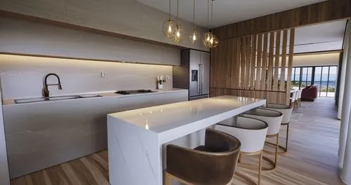 COCINA MODERNA UTILIZANDO MADERA EN LOS ESTANTES Y MARMOL EN UNA BARRA DE EN MEDIO ASI COMO SUS RESPECTIVOS BANCOS Y UNA LAMPARA COLGANTE EN MEDIO DE LA BARRA DIVIDIDO POR UNA CELOCIA ENTE COMEDOR Y C