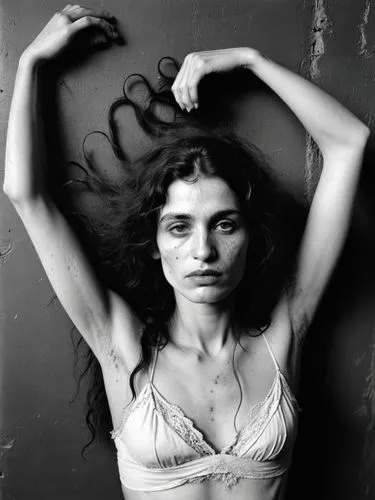 Black and white portrait of a pale, lower-class gypsy woman with blemished and blotchy skin who is in a trance. She has never shaved her dark underarm hair, which is very noticeable. The overall impre