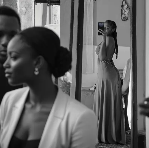 Beautyfull young african woman. Black and white. Watched by many spectators in a Fashion public show,girl in a long dress from the back,wedding photographer,bride getting dressed,video scene,in the mi