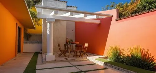 REMODELACION DE UNA CASA CON ESTILO MEXICANO, USO DE COLORES VIVOS, MADERA, PISOS DE BARRO, FLORES Y UN ESPEJO DE AGUA CON FUENTE EN UN MURO,a patio with table and chairs near large pink wall,patios,t