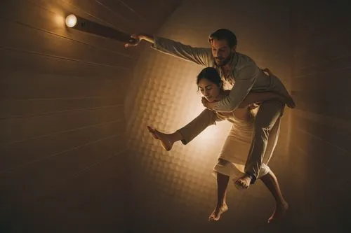 a naked woman is carrying a naked man on her back,man and woman dancing in a dark room with a wall lamp shining brightly on them,keersmaeker,two meters,lubezki,borgman,polunin,dolarhyde,Photography,Do