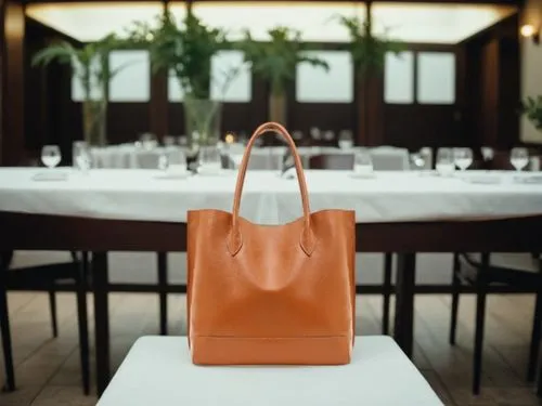 a close up view of a table with a long tablecloth, with a table set and a bag on the table,delvaux,birkin,smythson,longchamp,loewe,birkins,Small Objects,Indoor,Elegant Restaurant