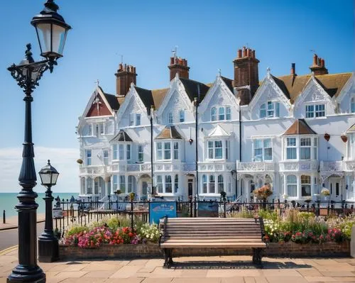 Bognor Regis seaside town, British architectural style, white stone buildings, intricate stonework, ornate facades, Victorian-era details, seagulls flying overhead, beachside promenade, iron railings,