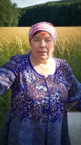 an older woman standing in the middle of a field,rigoberta,haudenosaunee,campesina,varda,uzbek,tatars,dreifuss,yamada's rice fields,akwesasne,barley cultivation,anousheh,abenaki,mataji,matveyeva,count