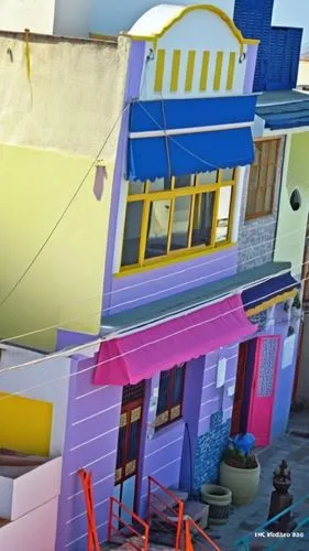 a multi colored building that is next to a staircase,balamory,colorful facade,valparaiso,moc chau hill,stilt houses,favelas,Photography,General,Realistic