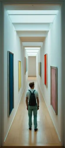 A man walks down a narrow central perspective white hallway with minimalist but colorful images on the walls, exhibition photography, interior scenery, professional photography,art gallery,art museum,