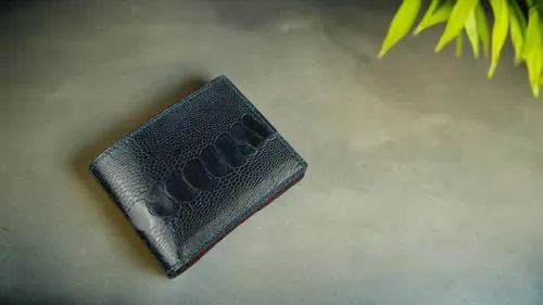 a small black wallet sitting on a grey table,wallet,wallets,cardholder,matchbook,moleskin,smythson