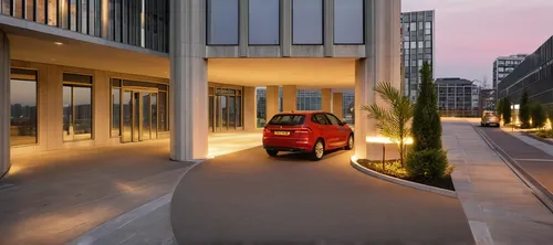 Residential glass building in busy metropolis area. close up look on the drive through and entrance with revolving door.,underground garage,volkswagen up,renault twingo,smart fortwo,car smart eq fortw