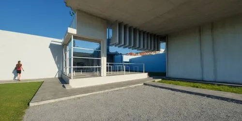 AREA DE CONVIVENCIA, CON PERGOLAS DE CONCRETO, LOSA CON REMATE DE VIGA DE ACERO, ESPEJO DE AGUA ,a person walking towards a building with columns,epfl,siza,champalimaud,quadriennale,kiasma,eisenman,Ph