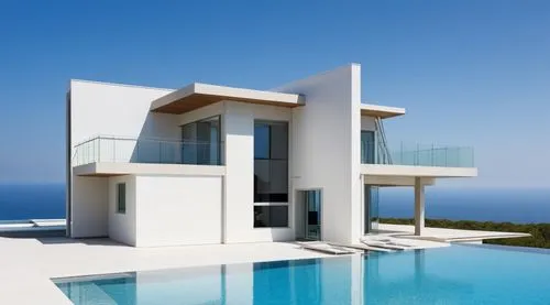 a modern residence, with glass balcony, dark themed finish, tan stone wall cladding, with an infinity pool,a pool in front of an modern white house with blue water,luxury property,modern house,inmobil