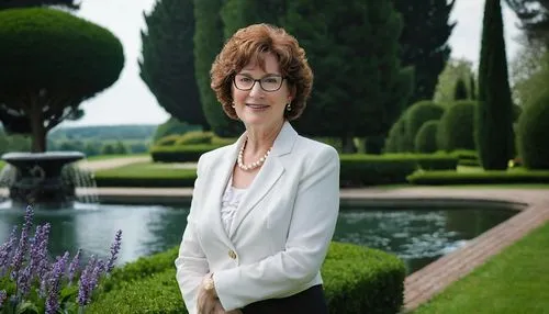 Debra A Kirkpatrick, landscape architect, mature lady, 50yo, glasses, short curly brown hair, gentle smile, elegant makeup, white blouse, black blazer, pencil skirt, high heels, standing, scenic garde