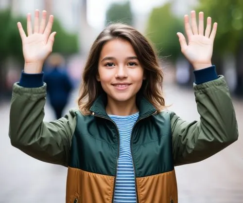 the  is posing for a po holding her hands up,waving,hand sign,girl with speech bubble,girl making selfie,girl holding a sign,hands behind head