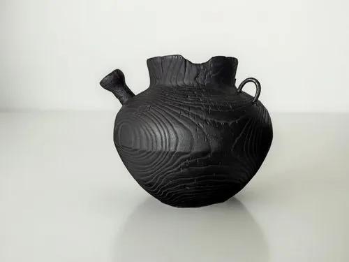 a vase is on the table near a white wall,clay jug,netsuke,amphora,kashira,jug,vase