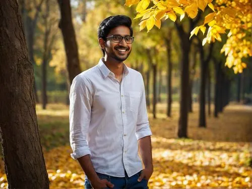 Young Indian man, Vishnu Prasad, 25 years old, strong facial features, black hair, short beard, brown eyes, glasses, casual wear, white shirt, dark blue jeans, sneakers, standing, relaxed posture, han