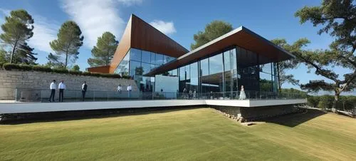 DISEÑO EXTERIOR DE UN COMEDOR  PARA UNA NAVE INDUSTRIAL, TERRAZAS CON MUROS DE PIEDRA, PERSONAS,CESPED, VENTANALES DE CRISTAL AMPLIOS, VISTAS PANORAMICAS, VEGETACION EXUBERANTE,a grassy field sitting 