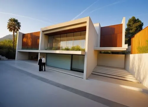 DISEÑO EXTERIOR DE UNA CASA RESIDENCIAL ESTILO MINIMALISTA, CON UN VENTANAL DE CRISTAL  EN EL AREA DE ACCESO PRINCIPAL, CANALES DE ACERO EN LA LOSA, ELMENTOS DE MADERA, MUROS COLOR BLANCO, COLORES NEU