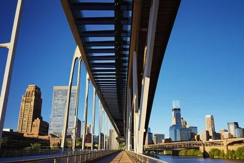 Minneapolis cityscape, modern skyscraper, sleek glass facade, angular rooftop, steel beams, urban landscape, Mill District, Stone Arch Bridge, Mississippi River waterfront, sunny afternoon, warm light