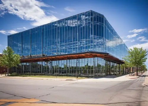 Oklahoma City, modern architecture firm, glass building, steel frame, wooden accents, urban setting, busy streets, cars passing by, blurred motion effect, daytime, sunny weather, clear blue sky, few c