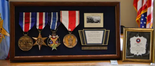 April 14, 2014: A framed photo and medals, including a Bronze Star, sit on display during a ceremony at which 91-year-old World War II veteran Frank Dechant received the United States Prisoner of War 