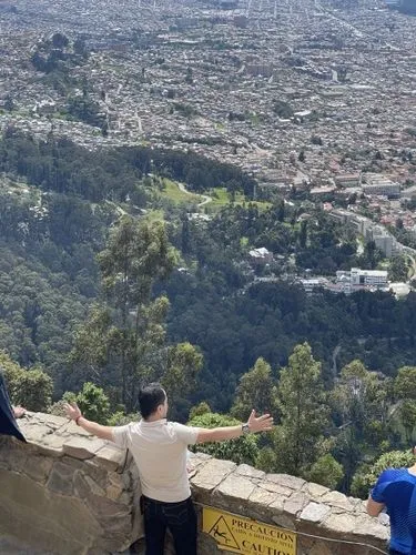 two men sitting on a cliff overlooking the city,rubidoux,klis,lycabettus,ehden,hollywood sign,pena de bernal,tijeras,guanajuato,steepest,runyon,cuernavaca,anacapri,cahuenga,granada,cholula,climbed,que