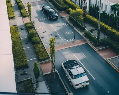 via en concreto 
hay una rampa que atraviesa la via es de color negro  
con dos caminos laterales en concreto que se conectan por las dos rampas 

solo hay dos carros 
hay personas 
hay un camino hori