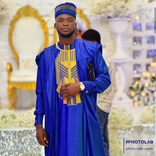 a man in blue standing in front of a christmas tree,enthronement,igwe,alaafin,golden weddings,bridegroom,momodu