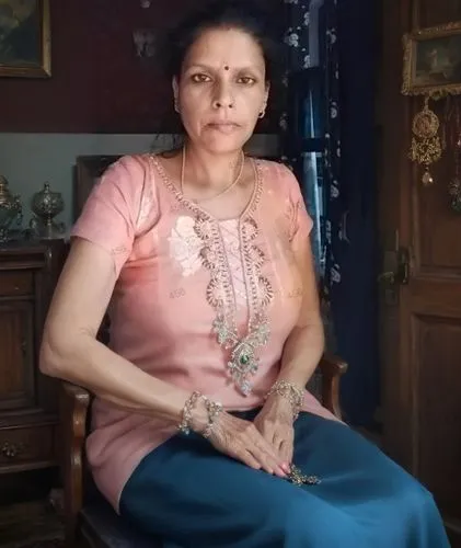 a woman sitting in a chair wearing a pink blouse and blue pants,mataji,rajmata,zubaida,upasana,gayatri,tanuja