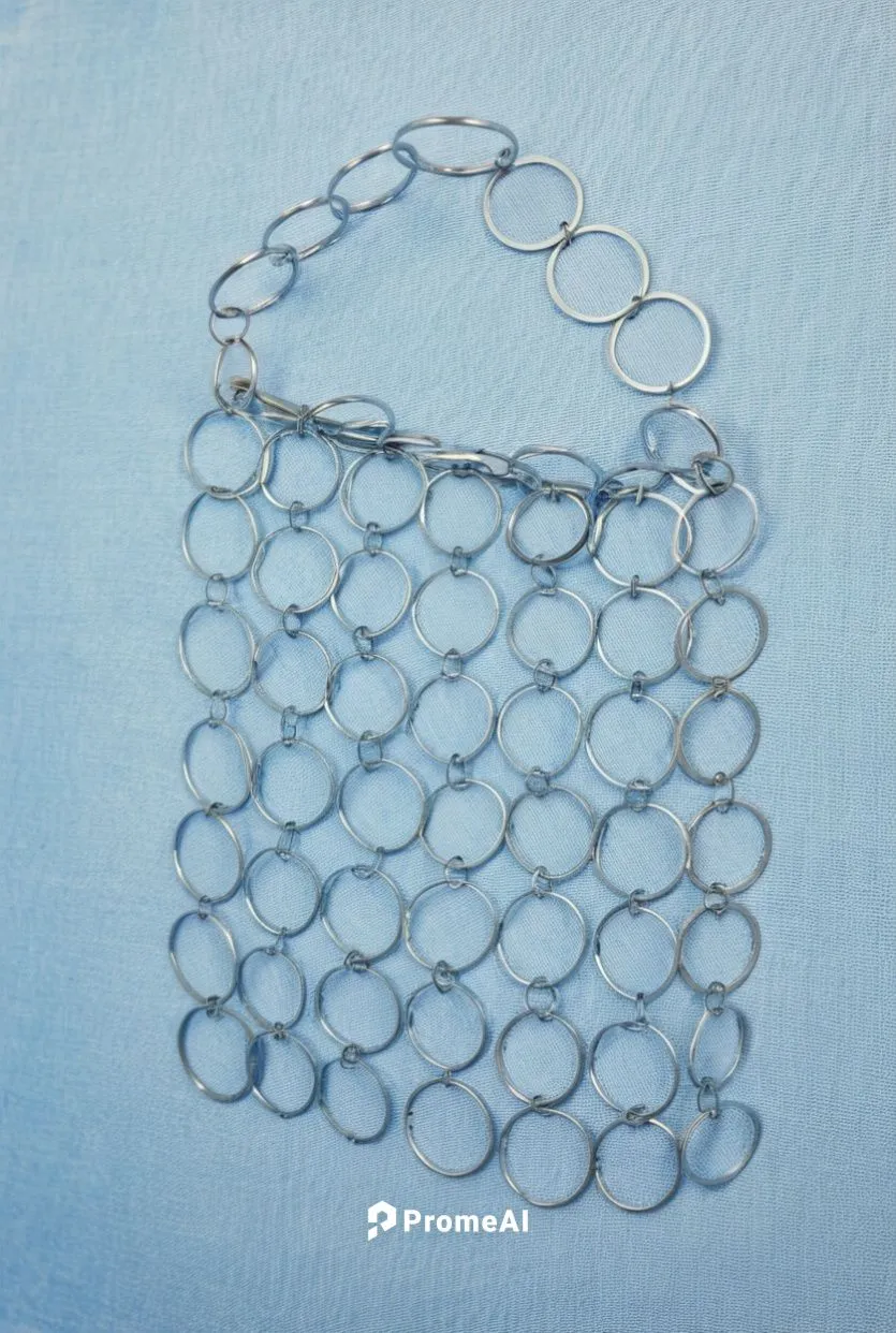 material del bolso tela vaquera
piezas circulares unidas por anillas pequeñas de metal gris muy claro
asa del bolso formada por la union de las piezas circulares
forro interior separado de los circulo