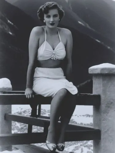 A lady from the 1940s in front of an Alpine backdrop.,an old po of a beautiful young lady sitting on a bench,jane russell-female,ingrid bergman,jane russell,stanwyck,maureen o'hara - female,myrna,Phot