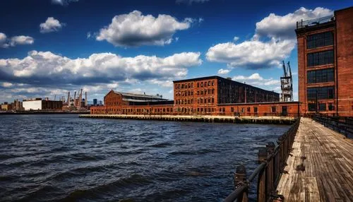 Brooklyn Navy Yard, modern industrial architecture, brick facade, large windows, metal frames, wooden docks, vintage nautical elements, rusty chain fences, old piers, urban waterfront, sunny afternoon