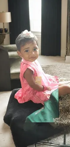 a baby doll sitting on a black table,akuapem,reema,alaia,dadlani,rajakumari,sitara