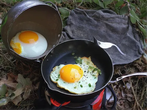 cooking eggs while backpacking,range eggs,free-range eggs,fried eggs,portable stove,brown eggs,fresh eggs,egg tray,garden breakfast,broken eggs,breakfast outside,cast iron skillet,yolks,camping equipm