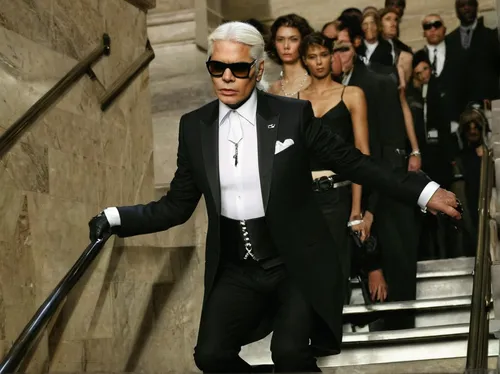 Karl Lagerfeld descends the staircase at Grand Central Terminal during Chanels Resort 2007 show in New York.,silver fox,woman in menswear,cruella de ville,karl,tuxedo just,james bond,tuxedo,spy visual