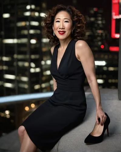 Sandra Oh, mature lady, elegant pose, high heels, tight black dress, bold red lipstick, curly brown hair, subtle smoky eyes, confident smile, city nightlife, skyscraper background, glamorous lighting,