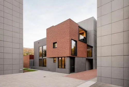 The modern brown brick house features a minimalist style with a dark gray painted ground floor and back. Located in an urban area, the design includes large windows for natural light. The materials us