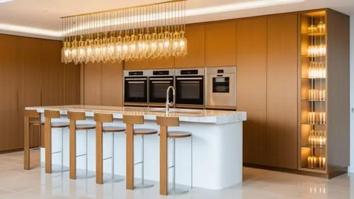 A kitchen that is a wall of tall cabinets in a light Sahara-beige shade
In the center of the cabinet wall there are 3 built-in ovens and a coffee machine similar to the ovens
A large central island wi