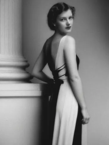 A lady from the 1940s in front of a classical column.,woman posing by column in black and white pograph,stanwyck,ziegfeld,ingrid bergman,norma shearer,feldshuh,olivia de havilland,Photography,Black an