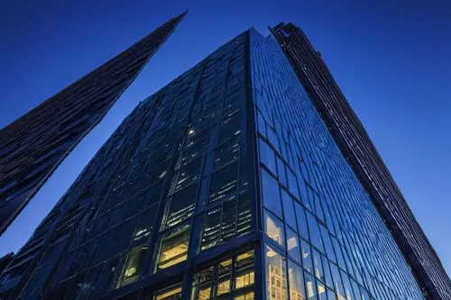 Modern JKS building, sleek lines, glass facade, steel beams, urban landscape, cityscape, skyscraper background, metropolitan atmosphere, blue hour, dramatic lighting, low-angle shot, 3/4 composition, 