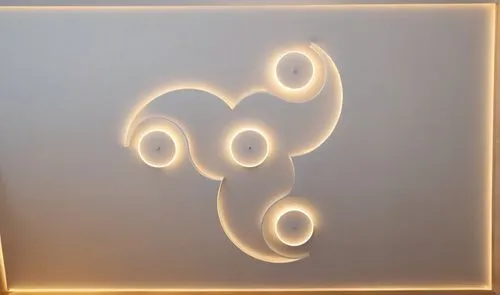 Gypsum decoration in the ceiling of a room with hidden LED lighting,the design is white and shows circles in the form of an intertwined shape,wall lamp,airbnb icon,airbnb logo,wall light,ganesha,eleph