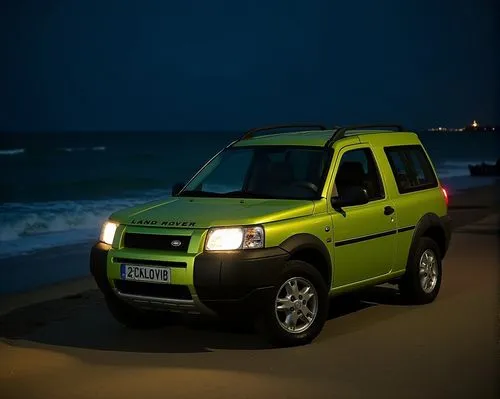 (High Definition HD) 2000 Land Rover freelander SUV 4x4w 3 door car decorated as a metallic lime 
low car, parked by the sea at night.,a bright yellow suv parked on the sand at night,jimny,freelander,