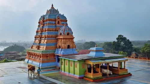 located in front of the busy market in bombay, india. villager and cow walking next to the temple.,Hindu temple on the mountain in Bombay.,sringeri,saman rattanaram temple,chaumukkha mandir,sreekovil,