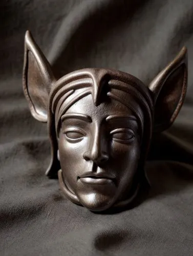 avec un style d'elfe
,there is a mask shaped like a devil's head,bastet,venetian mask,bronze sculpture,wadjet,sekhmet,netsuke