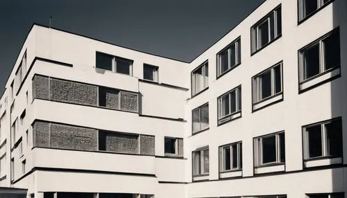 German Bauhaus architecture, modernist building, clean lines, rectangular forms, minimal ornamentation, functional design, white walls, large windows, steel frames, cantilevered rooflines, asymmetrica