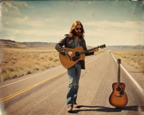 A late 1970s young man (((he has reddish hair, long hair and a beard, aviator sunglasses))) traveling alone, walking on the side of the road, in the Colorado highway (((he carries an acoustic guitar))