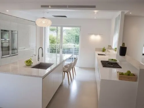 A kitchen design featuring only smooth, handleless cabinet fronts in pure white color. The cabinets have clean, modern lines, creating a minimalist and sleek aesthetic. The overall feel is one of orde