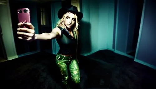 the girl in the black shirt and green pants is holding up her cellphone,loboda,girl making selfie,girl with a gun,paparizou,greenscreen,camera,girl with gun,chachi,matangi,lavigne,video scene,green sc