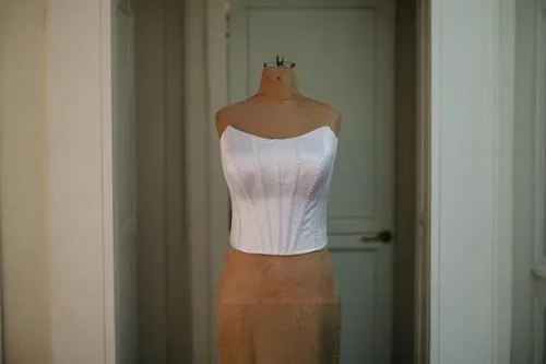 wooden mannequin,artist's mannequin,dress form,bodice,one-piece garment,sheath dress,garment,evening dress,cocktail dress,woman hanging clothes,wooden figure,strapless dress,see-through clothing,articulated manikin,torso,dressmaker,overskirt,women's clothing,mannequin,display dummy