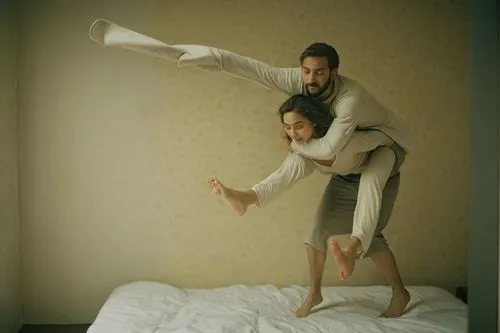 a naked woman is carrying a naked man on her back,two people standing on one end of a bed together,pillow fight,conceptual photography,pilobolus,two people,leapfrog,as a couple,Photography,Documentary